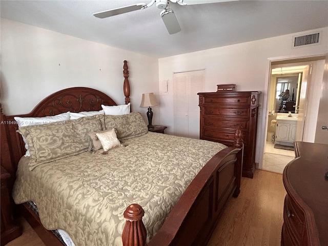 bedroom featuring connected bathroom, hardwood / wood-style floors, ceiling fan, and a closet