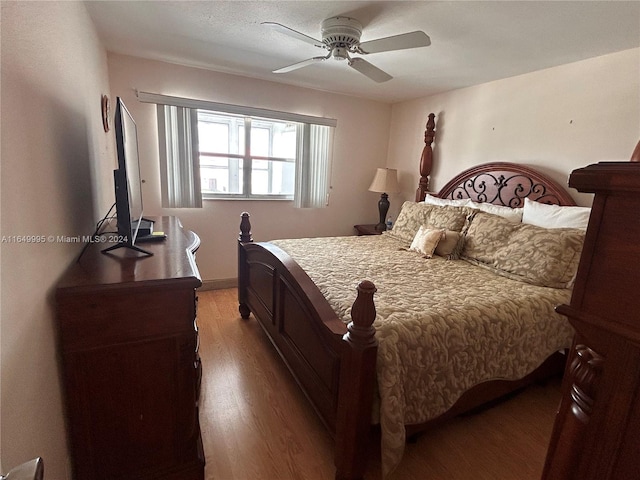 bedroom with ceiling fan and dark hardwood / wood-style floors