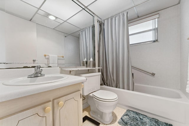 full bathroom featuring tile patterned floors, shower / bath combo, toilet, a paneled ceiling, and vanity