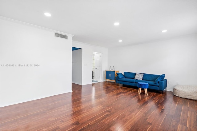 living room featuring dark wood-type flooring and ornamental molding