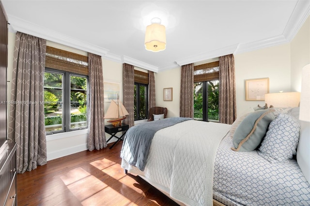 bedroom with dark wood-type flooring and crown molding