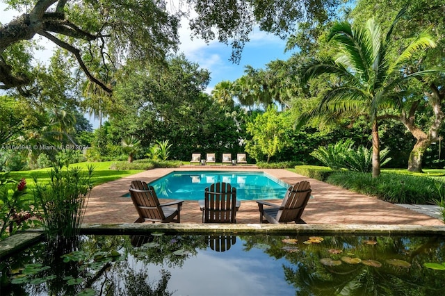 view of swimming pool featuring a patio and a water view