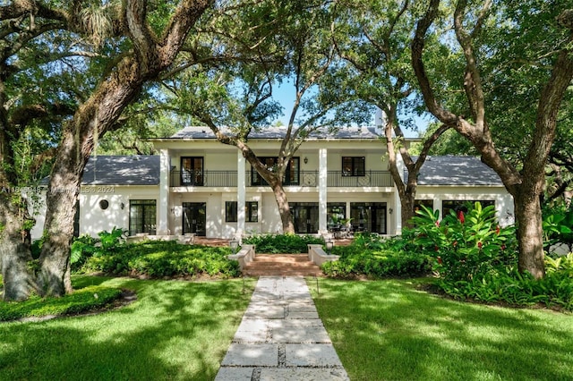 view of front of home with a balcony and a front yard