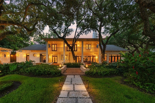 view of front of property with a lawn and a balcony