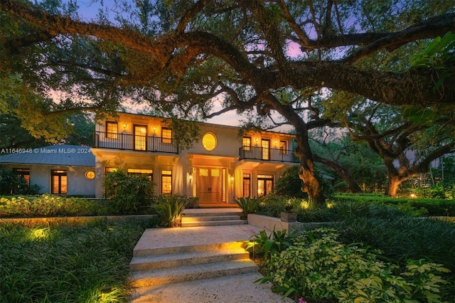 rear view of property with a patio, an outdoor living space, and a balcony