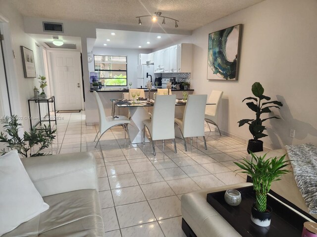 tiled dining room with a textured ceiling