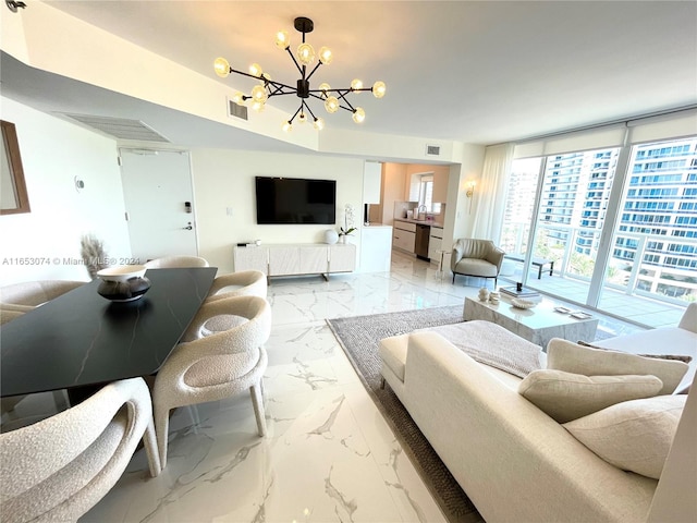 living room featuring a notable chandelier and a wall of windows