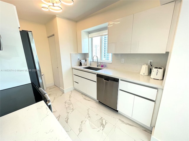 kitchen featuring white cabinets, dishwasher, light stone countertops, sink, and decorative backsplash