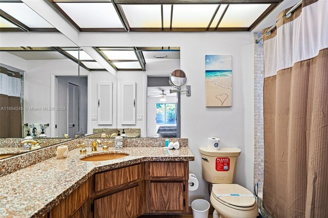 bathroom with a shower with curtain, ceiling fan, toilet, and vanity