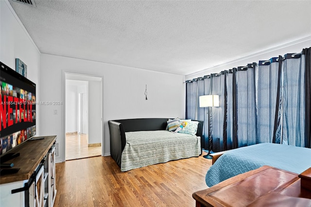 bedroom featuring wood-type flooring and a textured ceiling