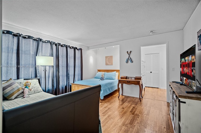 bedroom featuring hardwood / wood-style floors, a closet, and a textured ceiling