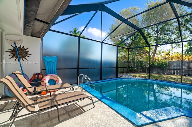 view of pool with glass enclosure and a patio