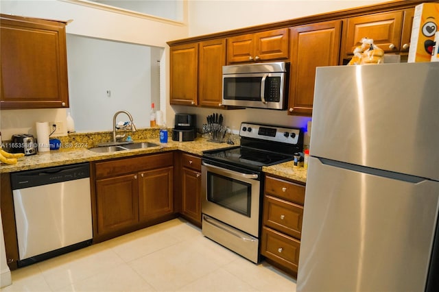 kitchen featuring light tile patterned floors, sink, light stone countertops, and appliances with stainless steel finishes