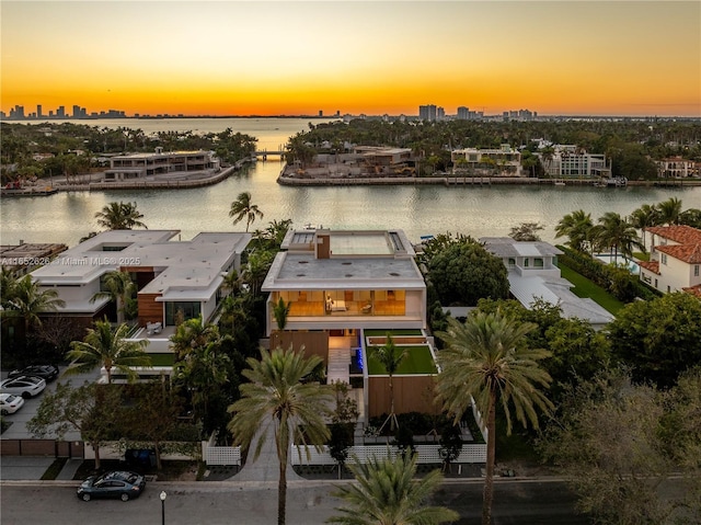 aerial view at dusk featuring a water view