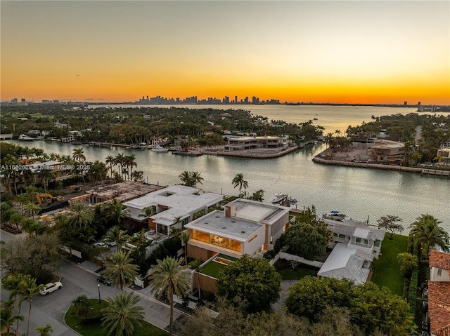 aerial view at dusk featuring a water view