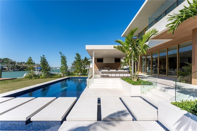 view of pool with a patio area and a water view