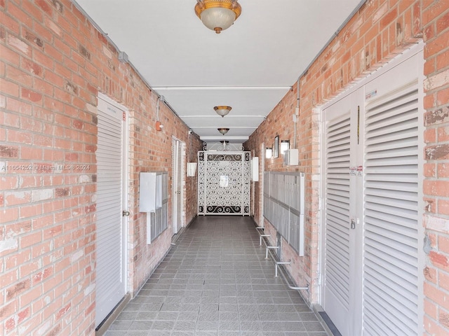 corridor with brick wall and dark carpet