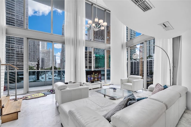 tiled living room featuring a high ceiling, plenty of natural light, and a notable chandelier