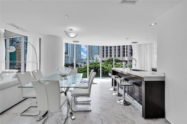 dining area featuring floor to ceiling windows and sink