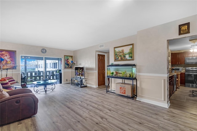 living room with ceiling fan and wood-type flooring