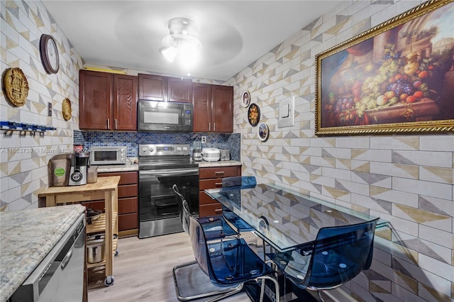 kitchen with appliances with stainless steel finishes, light hardwood / wood-style flooring, and ceiling fan