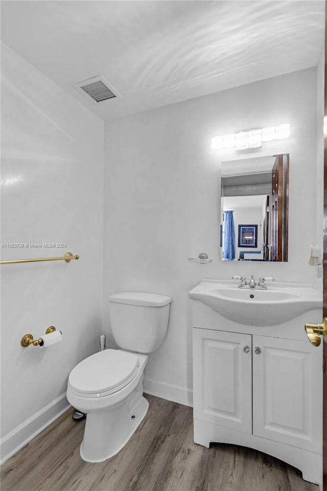 bathroom featuring vanity, toilet, and wood-type flooring