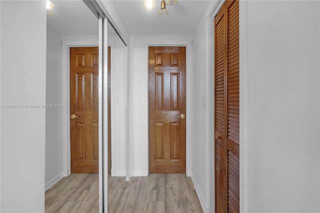 corridor with light hardwood / wood-style flooring and a barn door