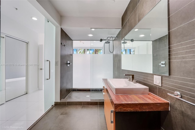 bathroom featuring a shower, tile walls, vanity, and tile patterned floors