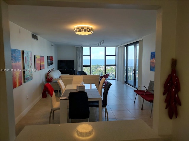 dining room with light tile patterned floors and a wall of windows