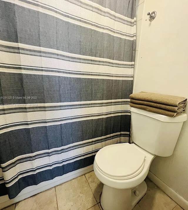 bathroom with toilet and tile patterned flooring