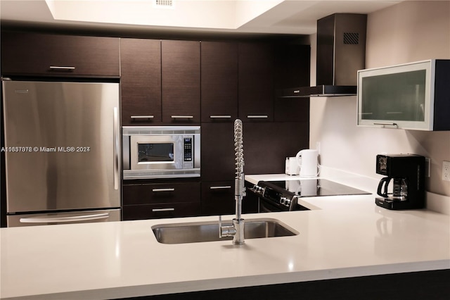 kitchen featuring stainless steel appliances, wall chimney exhaust hood, and dark brown cabinets