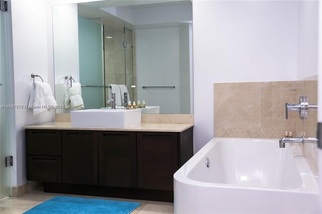 bathroom with tile patterned floors, a washtub, and vanity