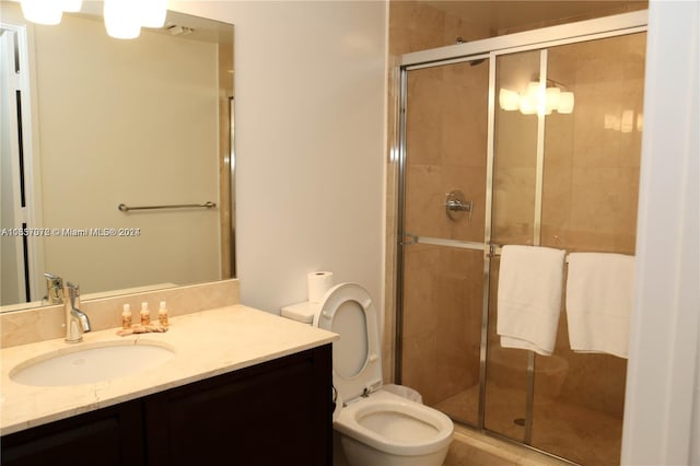 bathroom featuring vanity, toilet, and a shower with door