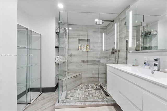 bathroom with vanity, a shower with shower door, and hardwood / wood-style flooring