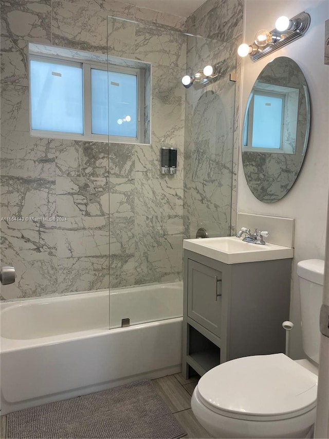 full bathroom featuring plenty of natural light, tiled shower / bath, toilet, and vanity