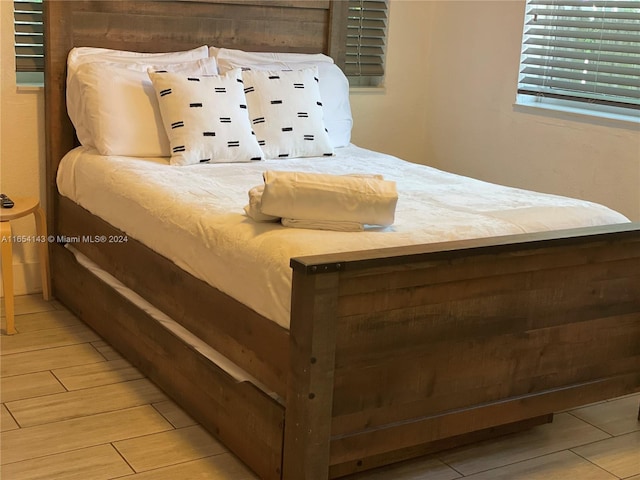 bedroom with wood walls and wood-type flooring