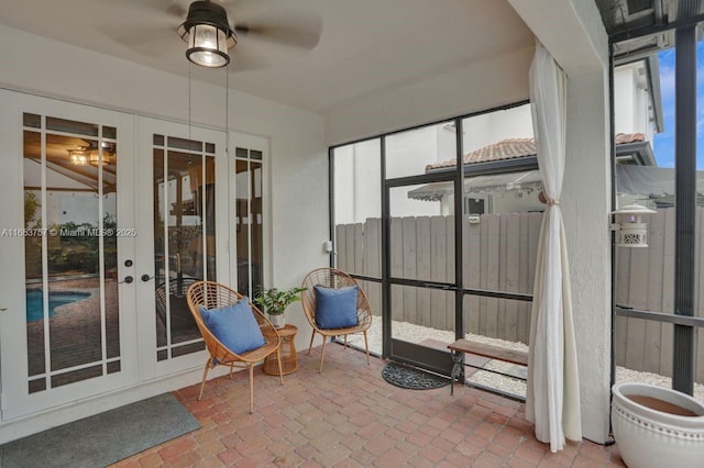 unfurnished sunroom with ceiling fan