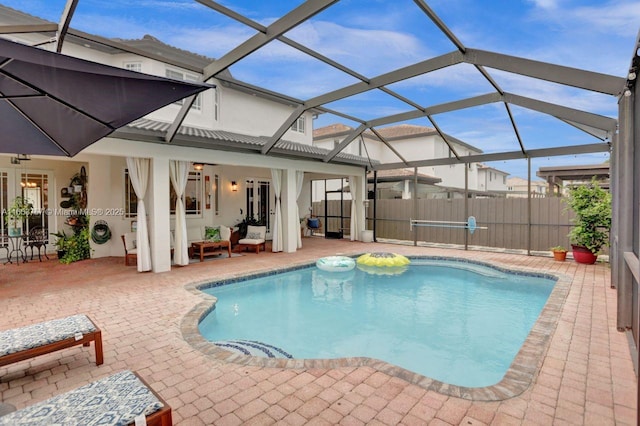 view of swimming pool featuring glass enclosure, an outdoor hangout area, and a patio