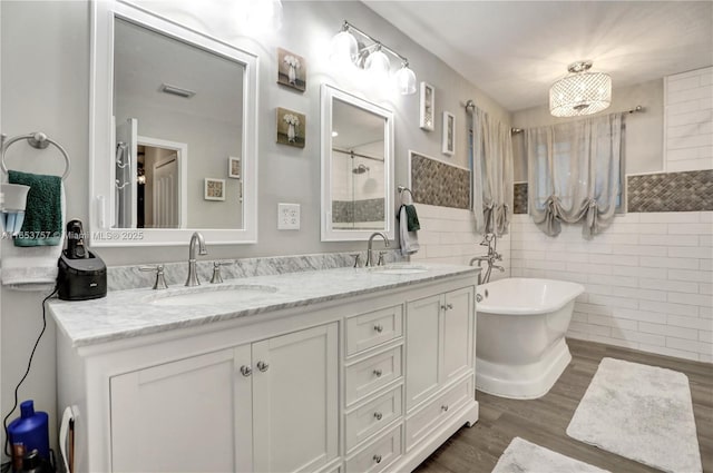 bathroom featuring hardwood / wood-style flooring, vanity, tile walls, and a washtub