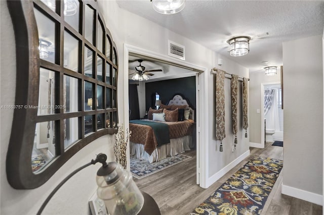 hall featuring hardwood / wood-style floors and a textured ceiling