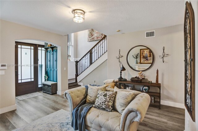 foyer entrance with wood-type flooring and a textured ceiling