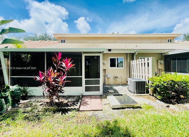 rear view of house featuring a sunroom and central AC