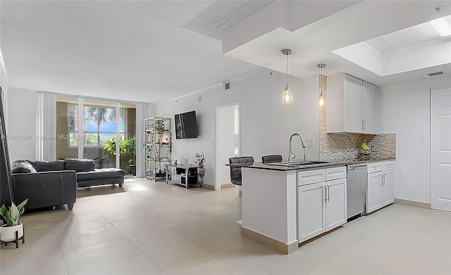 kitchen with a sink, visible vents, open floor plan, backsplash, and dark countertops