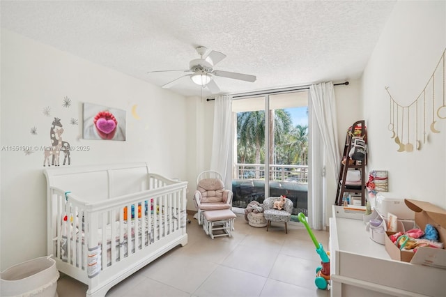 bedroom with access to outside, floor to ceiling windows, a ceiling fan, a textured ceiling, and a nursery area