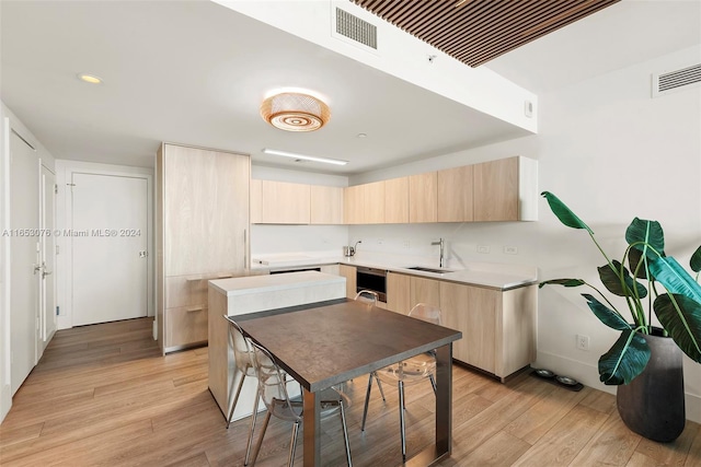 kitchen with visible vents, light wood-style flooring, light brown cabinets, and a sink