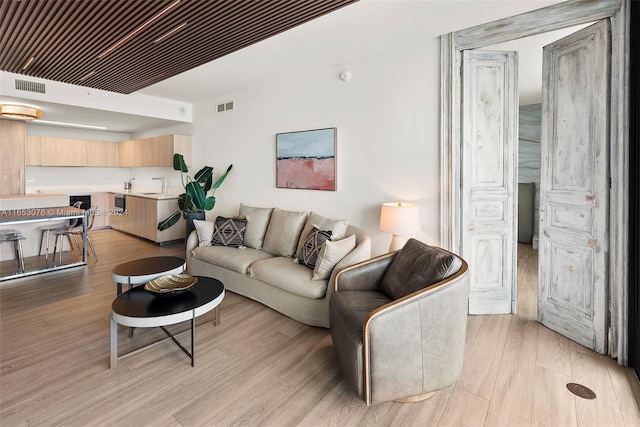 living room featuring light hardwood / wood-style flooring and sink