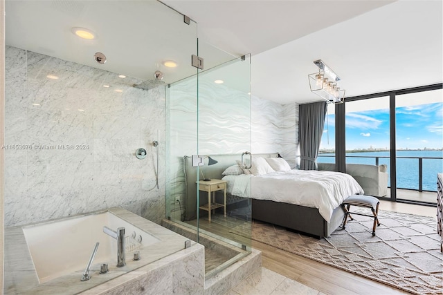 bedroom featuring a water view, tile walls, and access to exterior