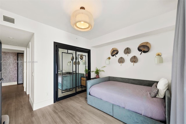 bedroom featuring wood finished floors, visible vents, and baseboards