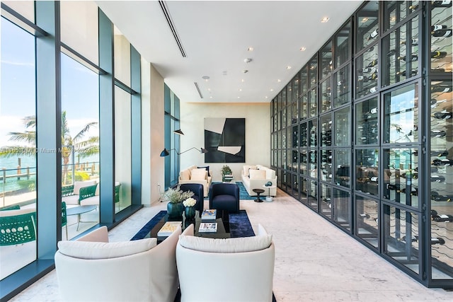 living room featuring recessed lighting, marble finish floor, and expansive windows