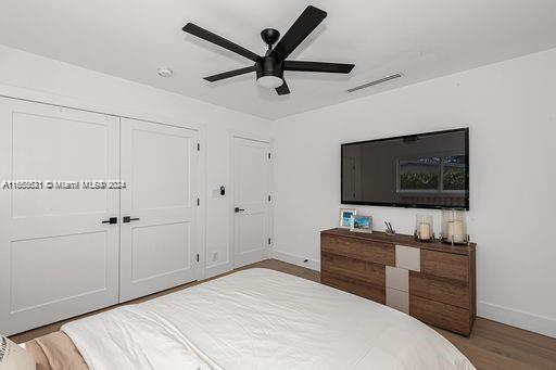 bedroom featuring light hardwood / wood-style flooring, ceiling fan, and a closet